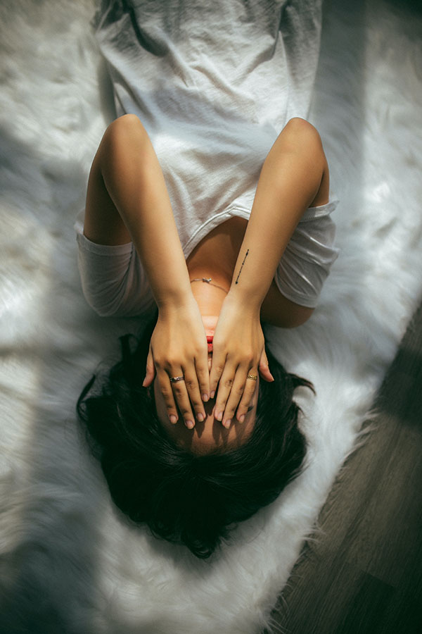 woman with depression laying on a bed
